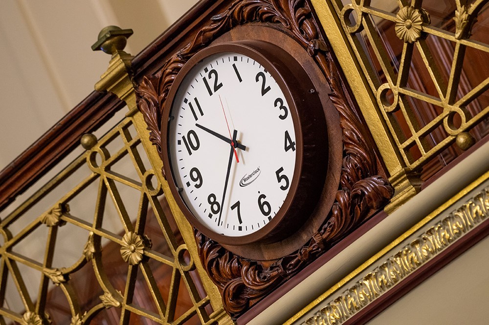 An ornate wooden clock shows the time as 10.38