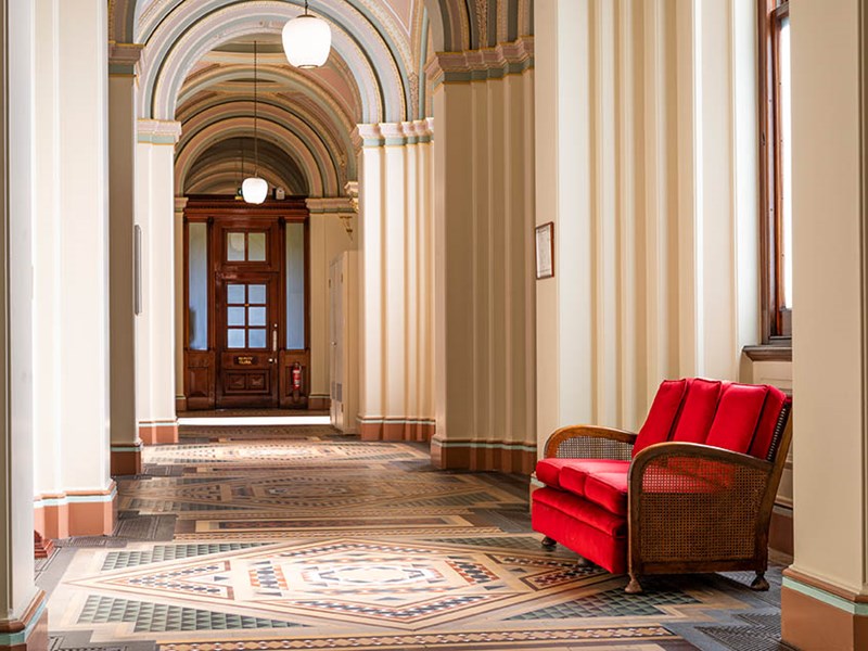 A hallway with ornate tiles and grand arches.