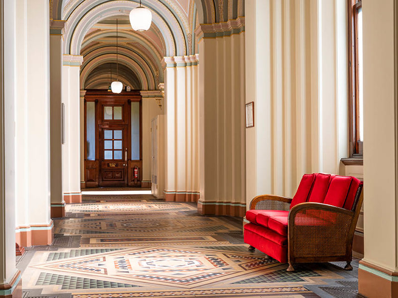 A hallway with ornate tiles and grand arches.