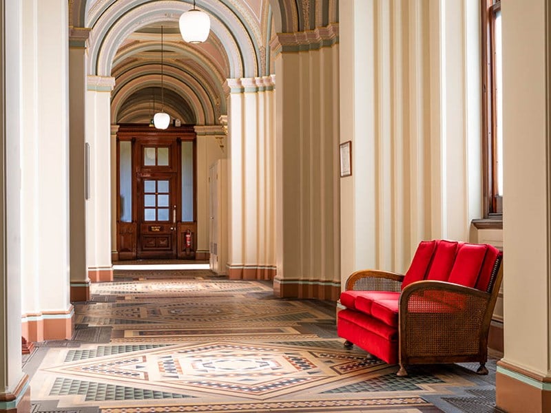 A hallway with ornate tiles and grand arches.