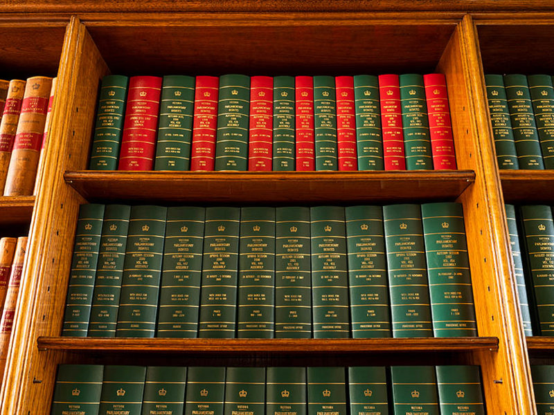 A bookshelf filled with leather-bound tomes.