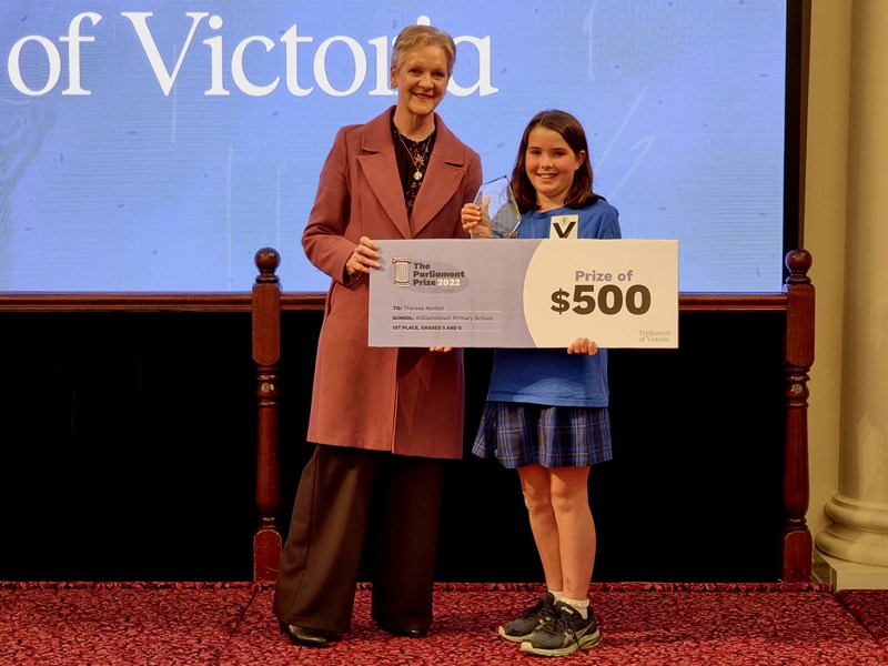 Legislative Assembly Speaker Maree Edwards presents grades 5-6 winner Theresa Morton with her trophy and prize money.